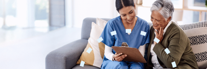 Nurse reviewing care plan with smiling senior woman at home.