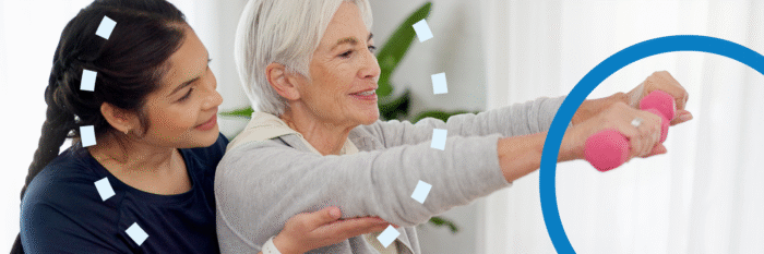 Senior woman exercising with light weights, guided by caregiver.
