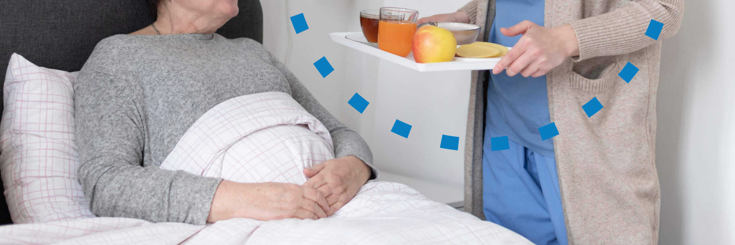 senior in bed talking to caregiver