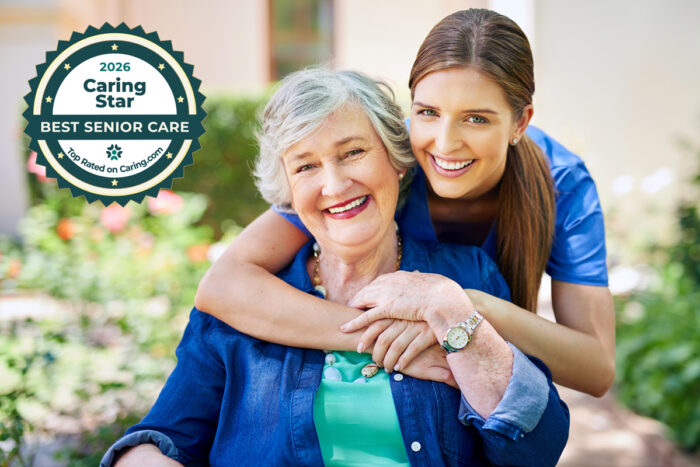 Caregiver and senior are happily embracing.