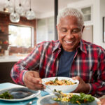 A senior couple enjoying a meal around the family table.