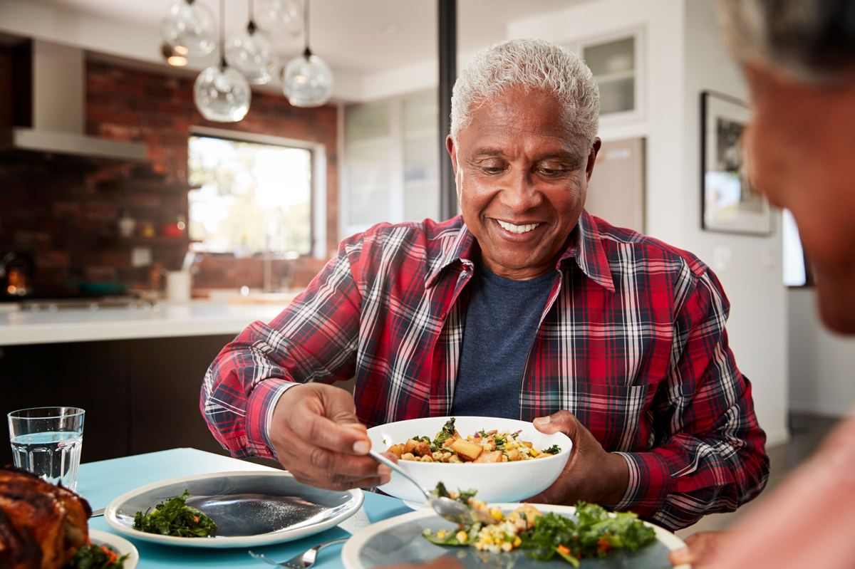 A senior couple enjoying a meal around the family table.