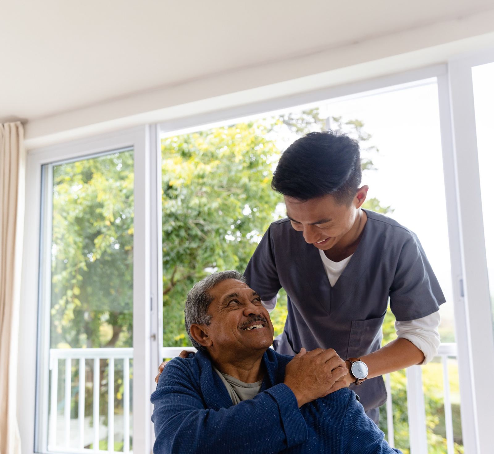 Caregiver supporting senior man during home visit